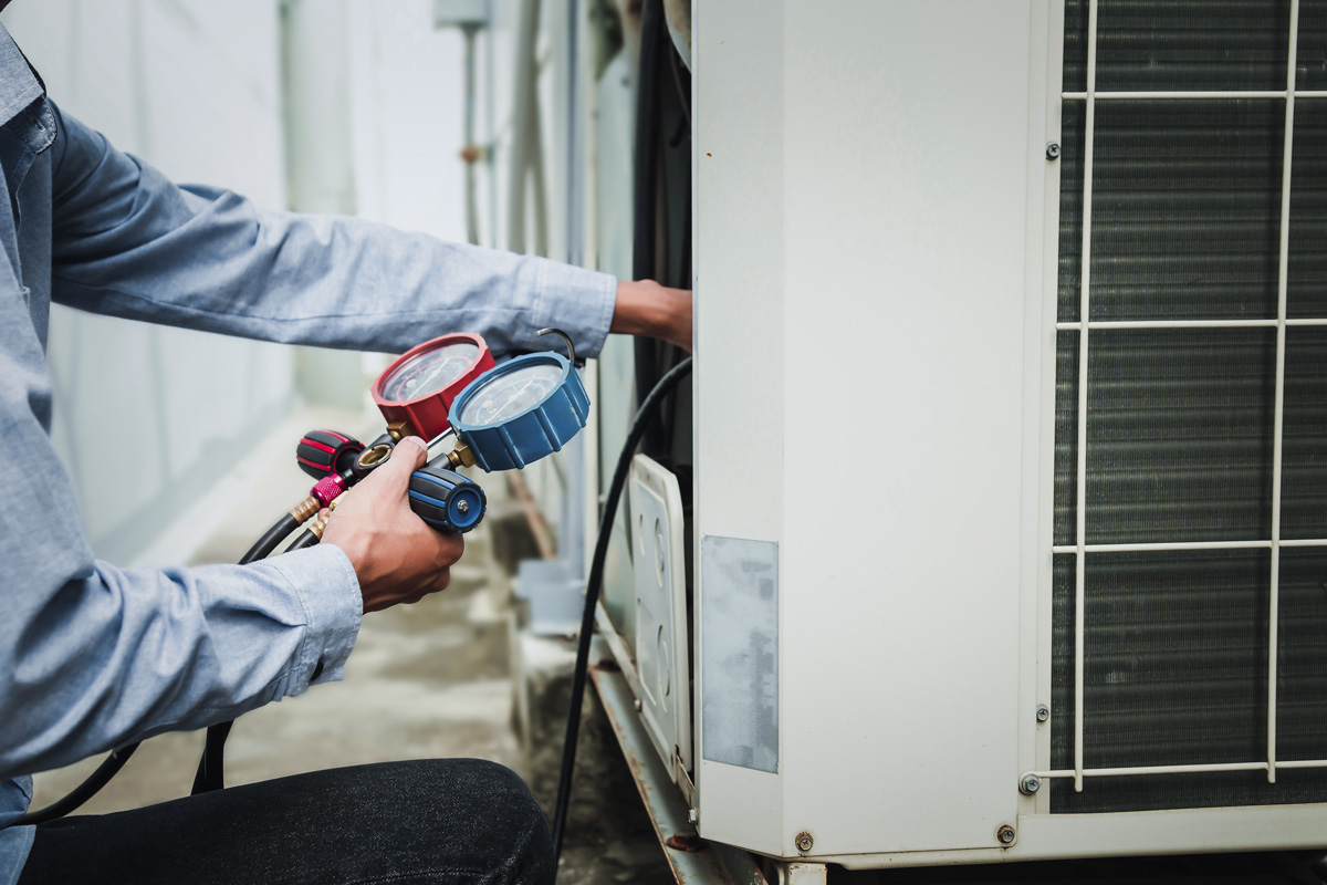 A person looking at pressure gauges while performing air conditioning repair in El Paso.